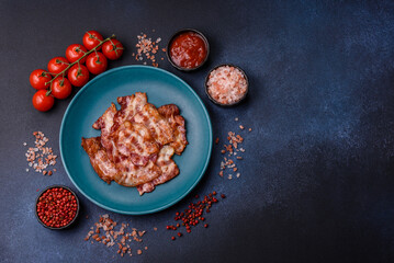 Cooked crispy fried pork bacon strips for a hearty breakfast. Fried bacon strips