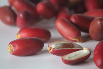 Red dates or jujubes close-up, whole & sliced with white flesh. Winter fruit, wellness and sweetness