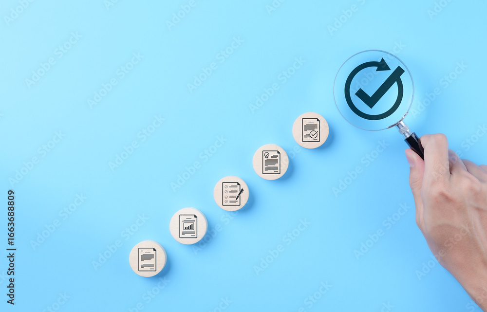 Poster document approval and quality assurance process concepts. hand holding a magnifying glass focusing o