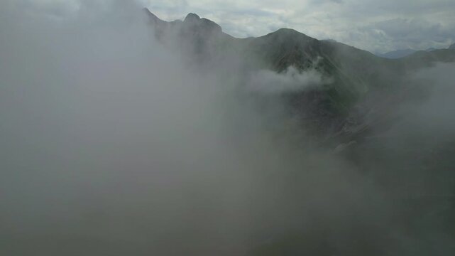 4K Aerial Drone video of the hike to the highest mountain top in Germany, Zugspitze on a moody foggy day with epic clouds and incredible nature. Famous alpine cabin Knorr Hut