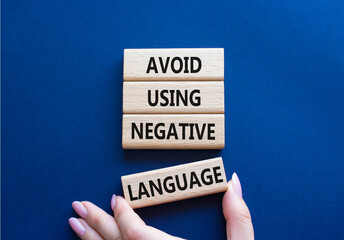 Negative Language symbol. Wooden blocks with words Avoid using Negative Language. Businessman hand....