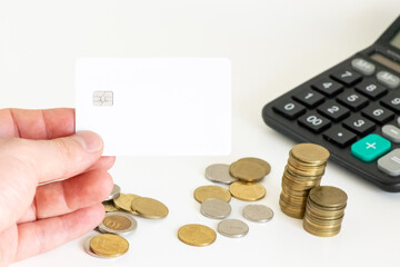 Hand holding blank credit card with wallet, cash and coins on background