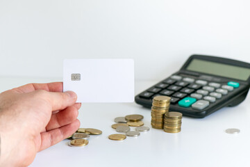 Hand holding blank credit card with wallet, cash and coins on background