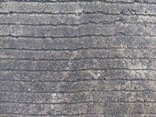 close up of rough concrete surface with engraved vertical striped texture