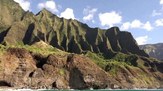 Explore the rugged beauty of the Na Pali Coast mountains in Kauai Hawaii on a sunny day