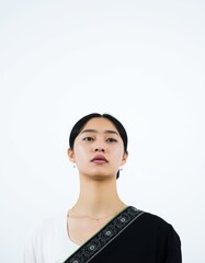 Portrait of a young woman with dark hair wearing a black and white patterned garment top