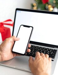 Hands using laptop and phone at Christmas