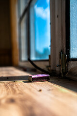 A matchbox by an unkempt window sill