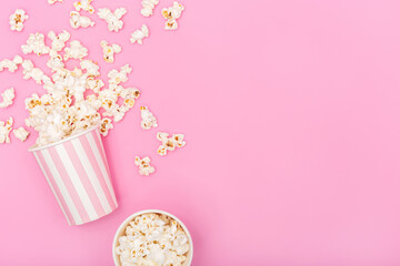 Popcorn bucket on pink background. Movie or TV background. Top view Copy space