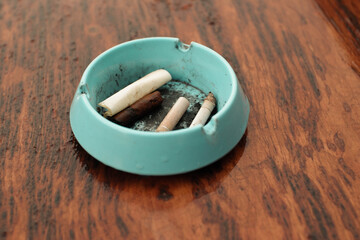 an ashtray containing cigarette butts on a wooden table