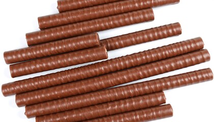 Close-up of a pile of chocolate wafer rolls on a white background.