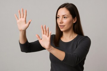 Young woman interacting with invisible digital screen using augmented reality or virtual reality technology