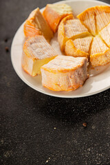 Cheese plate camembert, brie, munster french cheese tasty snack fresh delicious gourmet food background on the table rustic food top view copy space