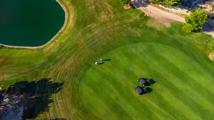 Aerial view of golf course with players and carts