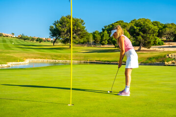 Fototapeta premium Golfer putting ball on green at golf course