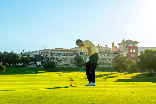 Golfer hitting ball on lush green golf course