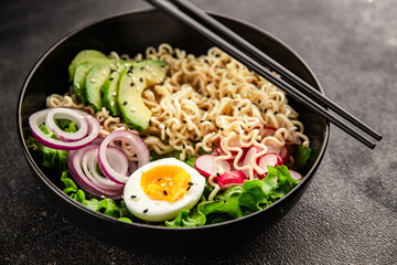 Vegetarian noodle bowl avocado, noodles, egg, vegetables tasty snack fresh delicious gourmet food background on the table rustic food top view copy space keto and paleo diet vegetarian food