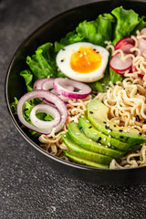 Vegetarian noodle bowl avocado, noodles, egg, vegetables tasty snack fresh delicious gourmet food background on the table rustic food top view copy space keto and paleo diet vegetarian food