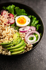 Vegetarian noodle bowl avocado, noodles, egg, vegetables tasty snack fresh delicious gourmet food background on the table rustic food top view copy space keto and paleo diet vegetarian food