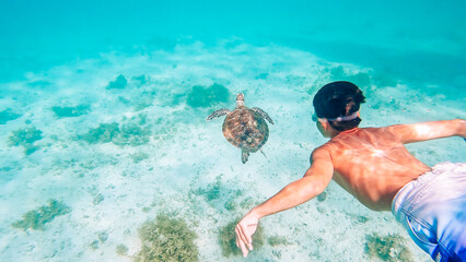 Child swimming with Sea turtle at Port Barton, Palawan, Philippines