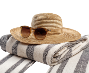 Summer vacation essentials with straw hat and sunglasses on towels on a transparent background, cut out