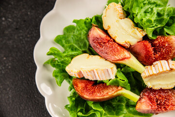 Salad figs, soft cheese, green leaf lettuce tasty snack fresh delicious gourmet food background on the table rustic food top view copy space keto and paleo diet vegetarian food