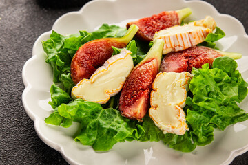 Salad figs, soft cheese, green leaf lettuce tasty snack fresh delicious gourmet food background on the table rustic food top view copy space keto and paleo diet vegetarian food