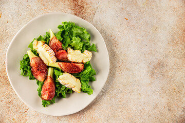 Salad figs, soft cheese, green leaf lettuce tasty snack fresh delicious gourmet food background on the table rustic food top view copy space keto and paleo diet vegetarian food
