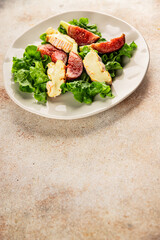 Salad figs, soft cheese, green leaf lettuce tasty snack fresh delicious gourmet food background on the table rustic food top view copy space keto and paleo diet vegetarian food