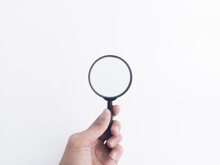 Hand holding a black magnifying glass on white background, symbolizing search, research, analysis, focus, and investigation with space for text.
