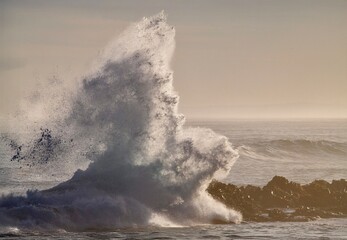 huge waves crashing on rocky beach