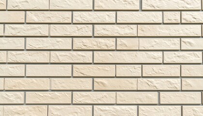 Obraz premium A neutral beige brick wall displays a regular, repeating pattern of rectangular blocks, with subtle textural variations, creating a calming aesthetic.