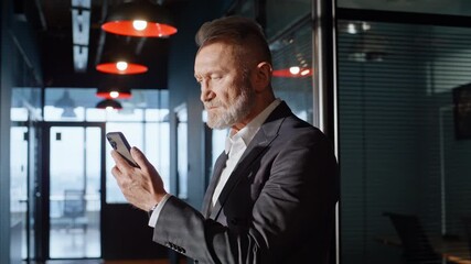Aged businessman worried cellphone message standing hallway in suit closeup. - Powered by Adobe