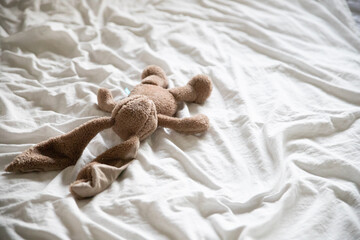 Soft brown stuffed animal on a bed