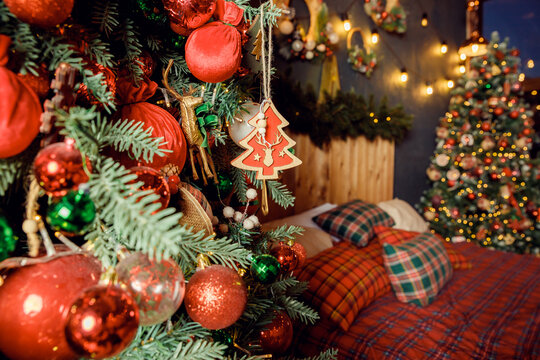 Classic Christmass or New Year decoration with a lot of gift boxes under spruce in a bedroom. Vintage New Year decor. Christmas mood. interior with New Year's holiday sparkling garland.