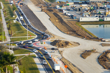 Roadworks construction site at roundabout intersection on American highway. Development of city circular transportation crossroads
