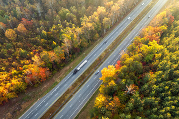 Elevated view of freeway road lanes between autumn mountain hills. Interstate transportation...