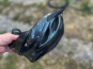 Cyclist holding carbon fiber bike helmet promoting safety and style