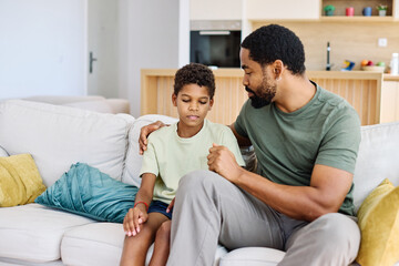Portrait of a teenage boy son talking to his father at home. Sharing secrets and problems, support...
