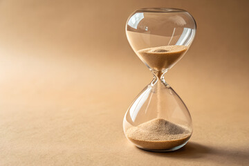 Hourglass sand timer isolated on beige plain backgrond