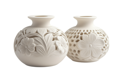Two ornate white ceramic vases with intricate floral carvings and pierced patterns, round bodies and narrow mouths