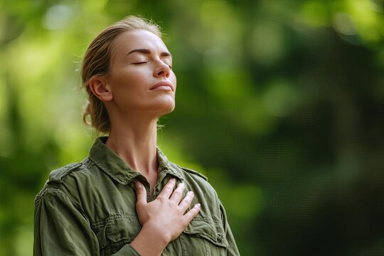 A woman breathes deeply with a serene expression in a lush green setting reflecting tranquility and mindfulness