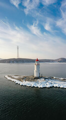 Aerial: view of the Tokarevsky lighthouse surrounded by ice at dawn