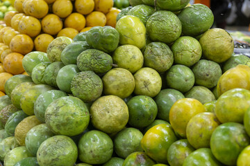 Green and yellow passion fruits piled up at a market stall.
