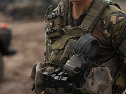 Close-up of military communications and tactical equipment worn by service member