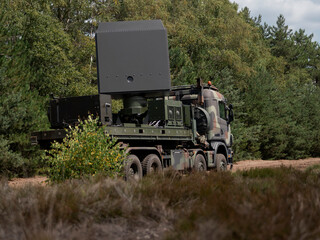 Mobile military radar system mounted on truck in natural field environment