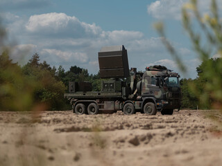 Fototapeta premium Military radar system truck with extended antenna array in field deployment configuration
