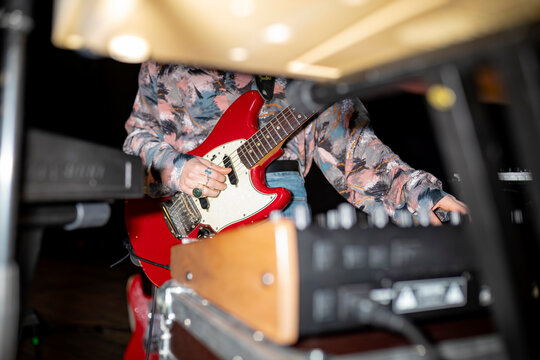 Guitarist with red guitar in professional studio setting - Powered by Adobe