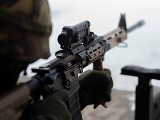 Close-up view of military assault rifle with scope and tactical accessories