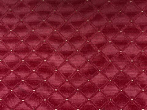 Red fabric with diamond geometric pattern and gold accents, textile background for upholstery, carpet, and interior design